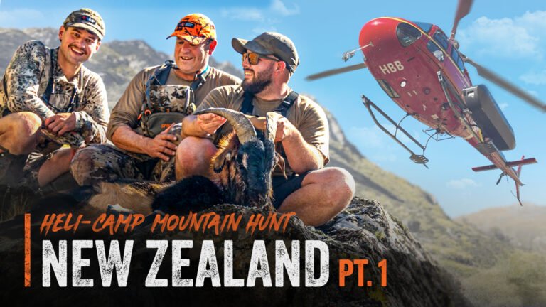 Bo, Ian and Jack pose with a Billy goat in the New Zealand Mountains. A helicopter flies overhead with the text "Heli-camp mountain hunt, New Zealand, pt.1